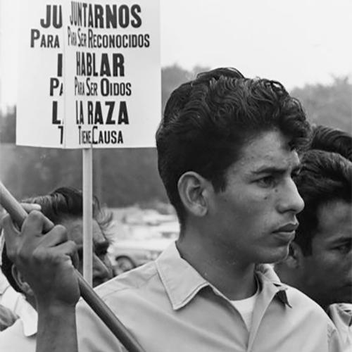 An Obreros Unidos (United Workers) member holding a sign, possibly like those in the background, that says 'Juntarnos Para Ser Reconocidos/Hablar Para Ser Oidos/La Raza Tiene Causa' which translates to 'Join To Be Recognized/Speak to Be Heard/The People Have A Cause.' On August 15, 1966, 24 marchers left Wautoma, Wisconsin, headed west to Coloma, then south along State Highway 51 and reached the Capitol in Madison after five days and eighty miles of walking. Led by Jesús Salas, marchers went to state agencies to present the following demands: $1.25 minimum wage; better housing; insurance for accidents and hospitalization; public toilet facilities for farm worker use; and a meeting with the Governor's Committee on Migratory Labor.            Obreros Unidos grew in Wisconsin during the 1960s and had deep roots in South Texas and Mexico. It was formed to deal with discrimination and oppression migrant farm workers were facing while working and living in Wisconsin and elsewhere along the journey to the North. In 1946, more than 4,000 farmworkers from Texas migrated to Wisconsin to cultivate and harvest vegetable and fruit crops. In 1961,85 percent of about 18,000 migrant workers, including 5,000 children under age 16, were recruited from Texas to work in Wisconsin.            Obreros Unidos marchan hacia Madison            Un miembro de Obreros Unidos sosteniendo un letrero, posiblemente uno como otros en el fondo, que dice 'Juntarnos Para Ser Reconocidos/Hablar Para Ser Oídos/La Raza Tiene Causa' y se traduce a 'Join To Be Recognized/Speak to Be Heard/The People Have A Cause' en inglés. El 15 de agosto de 1966, 24 manifestantes se fueron de Wautoma, Wisconsin, siguiendo al oeste hacia Coloma, luego al sur a lo largo de la carretera estatal State Highway 51, y llegaron al Capitolio en Madison después de cinco días y ochenta millas caminando. Dirigidos por Jesús Salas, los manifestantes visitaron agencias estatales para presentar las siguientes demandas: un sueldo mínimo de $1.25 por hora; mejores viviendas; seguro de accidentes y hospitalización; baños públicos para uso de los trabajadores; y una junta con el Governor's Committee on Migratory Labor (comité del gobernador que trata con la fuerza laboral migratoria).            Obreros Unidos se desarrollo en Wisconsin durante los años 1960 y tenía raíces profundas en el sur de Texas y México. Fue fundado para combatir la discriminación y opresión que los trabajadores agrícolas emigrantes estaban sufriendo mientras trabajaban y vivían en Wisconsin y en otros lugares a lo largo de su viaje al norte. En 1946, más de 4,000 trabajadores agrícolas de Texas emigraron hacia Wisconsin para cultivar y cosechar vegetales y fruta. En 1961, 85 por ciento de aproximadamente 18,000 trabajadores emigrantes, incluyendo 5,000 niños menores de 16 años, fueron reclutados de Texas para trabajar en Wisconsin.